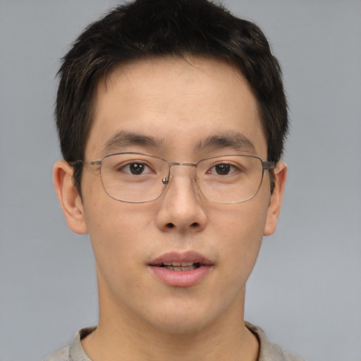 Joyful asian adult male with short  brown hair and brown eyes