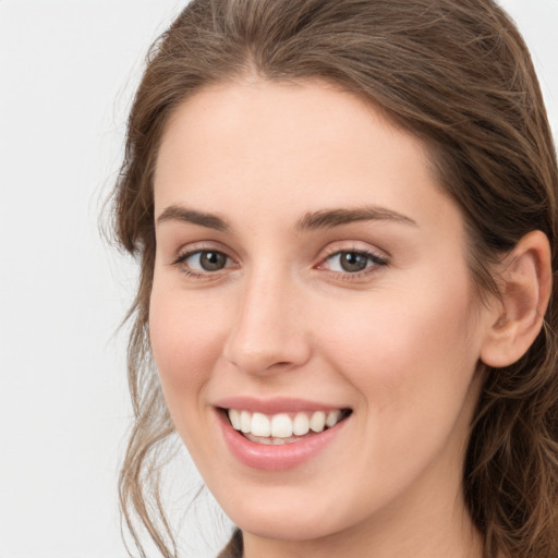 Joyful white young-adult female with long  brown hair and green eyes