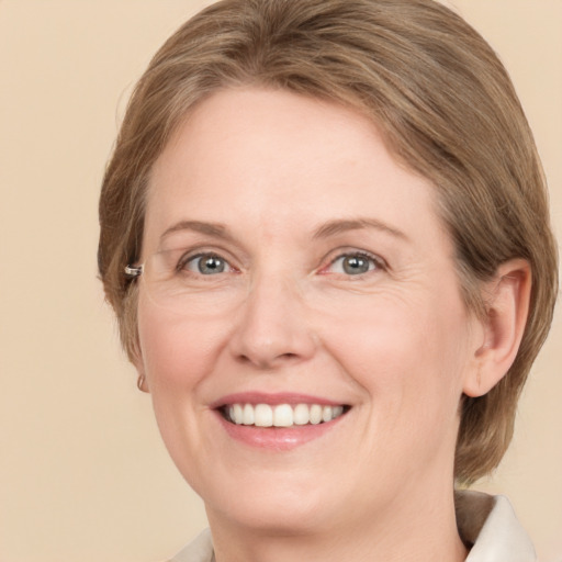 Joyful white adult female with medium  brown hair and grey eyes