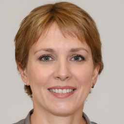 Joyful white adult female with medium  brown hair and grey eyes