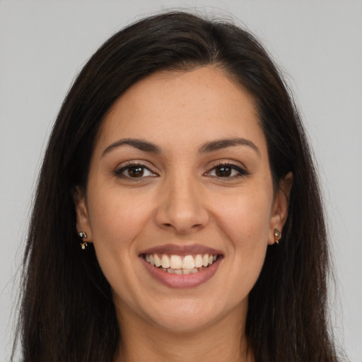 Joyful latino young-adult female with long  brown hair and brown eyes