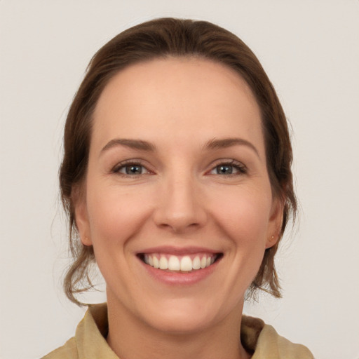 Joyful white young-adult female with medium  brown hair and grey eyes