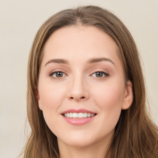 Joyful white young-adult female with long  brown hair and green eyes