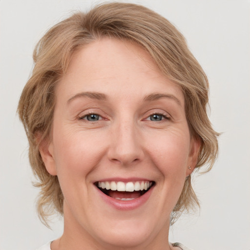 Joyful white young-adult female with medium  blond hair and blue eyes