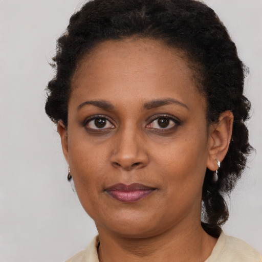 Joyful black adult female with short  brown hair and brown eyes