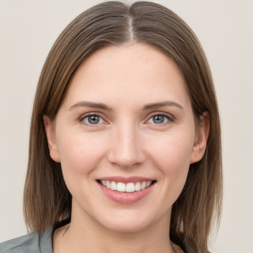 Joyful white young-adult female with medium  brown hair and grey eyes