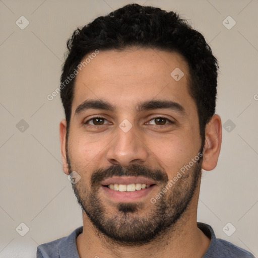 Joyful white young-adult male with short  black hair and brown eyes