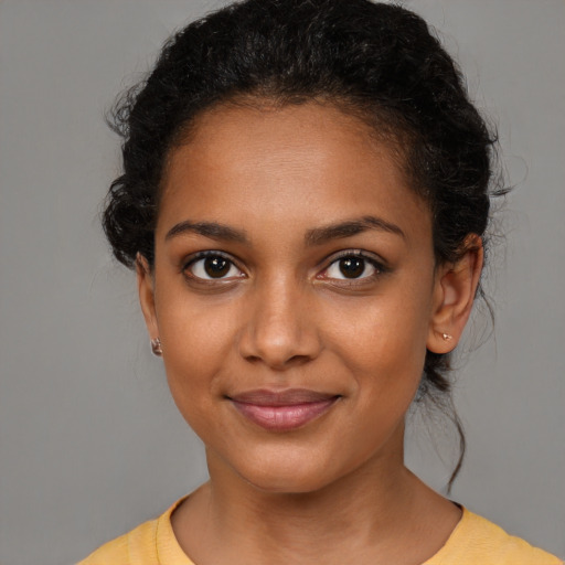 Joyful black young-adult female with medium  brown hair and brown eyes