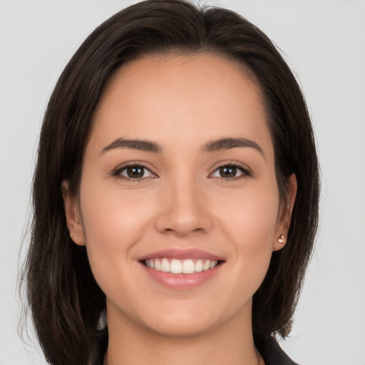 Joyful white young-adult female with long  brown hair and brown eyes