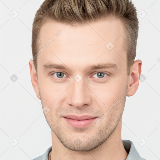 Joyful white young-adult male with short  brown hair and grey eyes