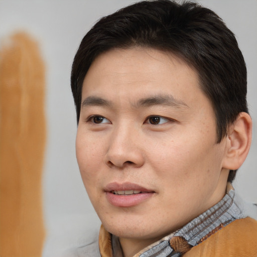 Joyful asian young-adult male with short  brown hair and brown eyes
