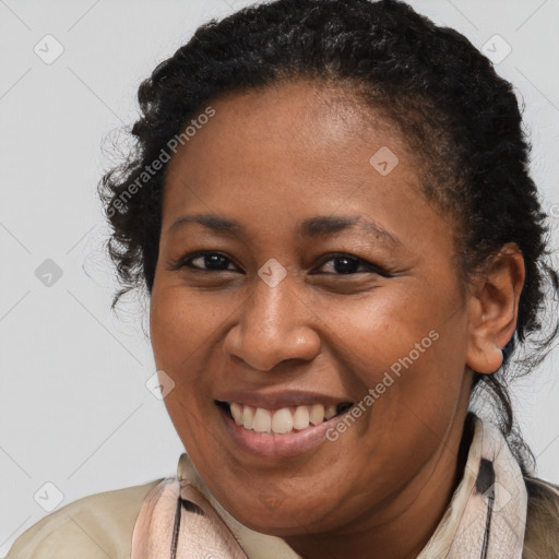 Joyful black young-adult female with long  brown hair and brown eyes