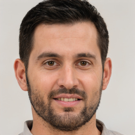 Joyful white young-adult male with short  black hair and brown eyes