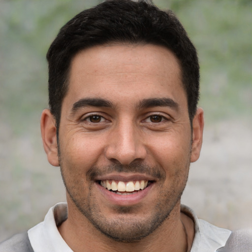 Joyful white young-adult male with short  black hair and brown eyes
