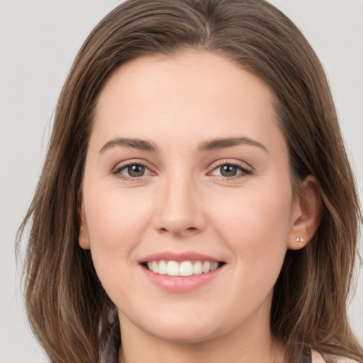 Joyful white young-adult female with long  brown hair and grey eyes