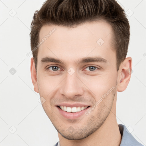 Joyful white young-adult male with short  brown hair and grey eyes