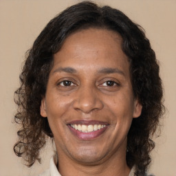 Joyful black adult female with medium  brown hair and brown eyes