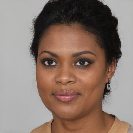 Joyful black young-adult female with long  brown hair and brown eyes