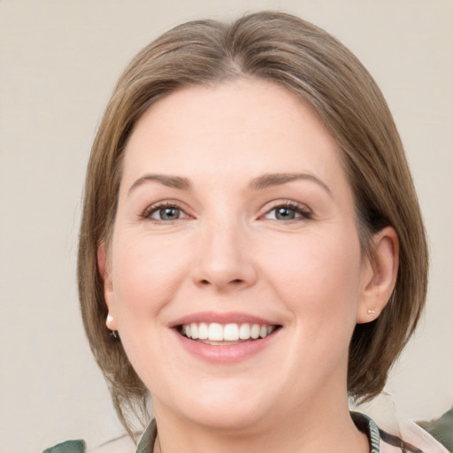 Joyful white young-adult female with medium  brown hair and green eyes