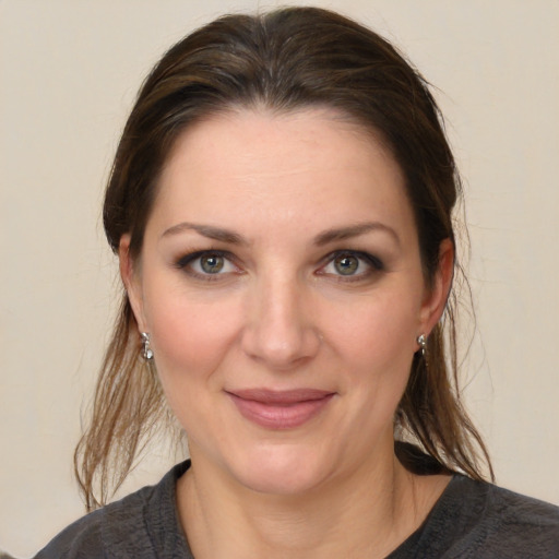 Joyful white young-adult female with medium  brown hair and grey eyes