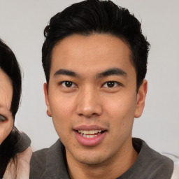 Joyful asian young-adult male with short  black hair and brown eyes