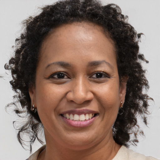 Joyful black adult female with medium  brown hair and brown eyes