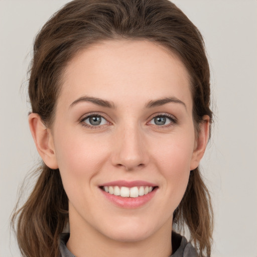 Joyful white young-adult female with medium  brown hair and grey eyes