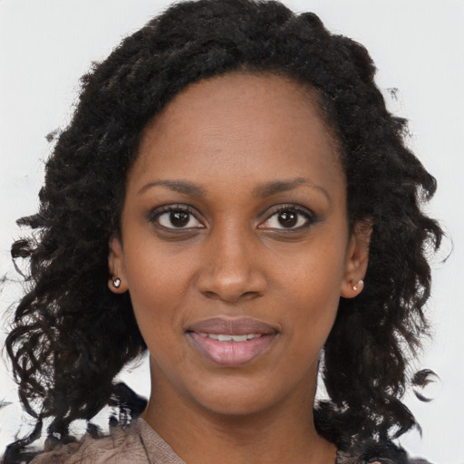 Joyful black young-adult female with long  brown hair and brown eyes