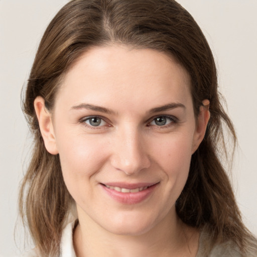 Joyful white young-adult female with medium  brown hair and grey eyes