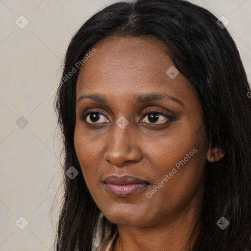 Joyful black adult female with long  brown hair and brown eyes