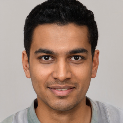 Joyful latino young-adult male with short  black hair and brown eyes