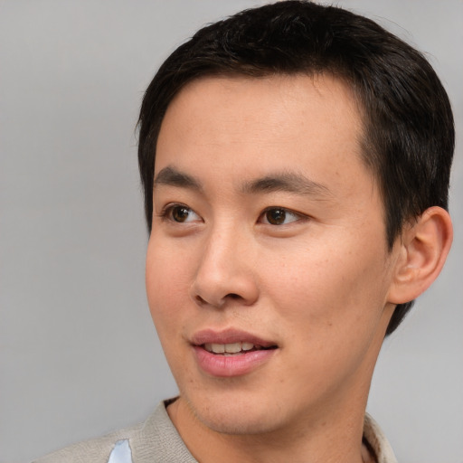 Joyful asian young-adult male with short  brown hair and brown eyes
