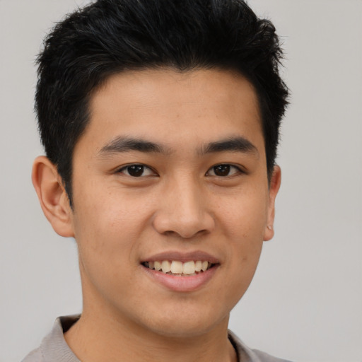 Joyful asian young-adult male with short  brown hair and brown eyes