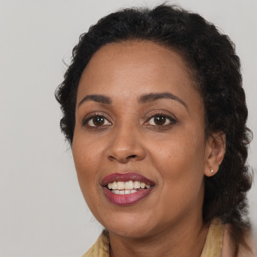 Joyful black adult female with long  brown hair and brown eyes