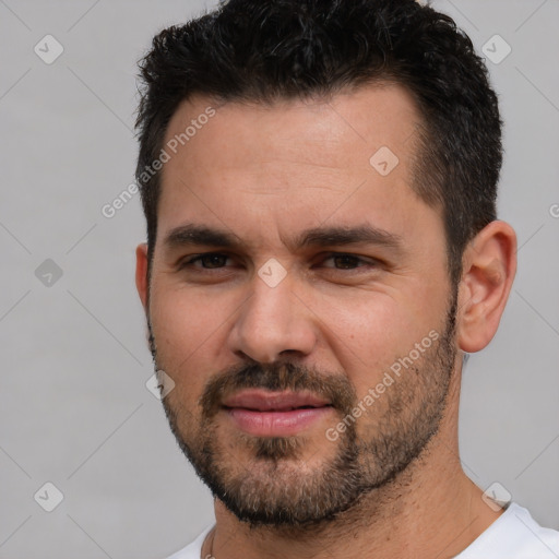 Joyful white young-adult male with short  black hair and brown eyes