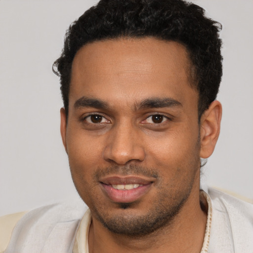 Joyful black young-adult male with short  brown hair and brown eyes