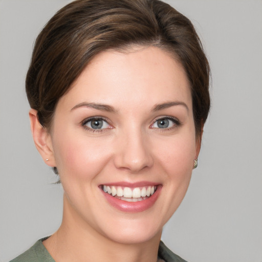 Joyful white young-adult female with short  brown hair and grey eyes