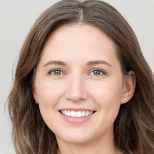 Joyful white young-adult female with long  brown hair and grey eyes