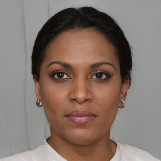 Joyful black young-adult female with short  brown hair and brown eyes