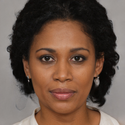 Joyful black adult female with medium  brown hair and brown eyes