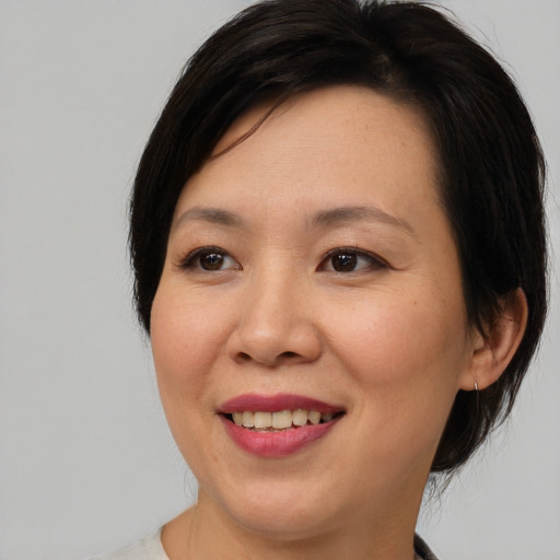 Joyful asian young-adult female with medium  brown hair and brown eyes