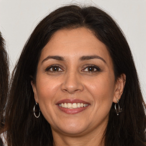 Joyful white adult female with long  brown hair and brown eyes
