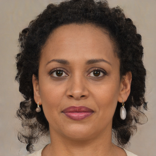 Joyful black young-adult female with medium  brown hair and brown eyes