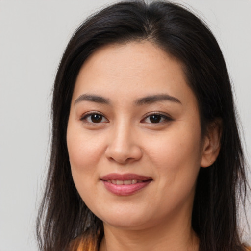 Joyful asian young-adult female with long  brown hair and brown eyes