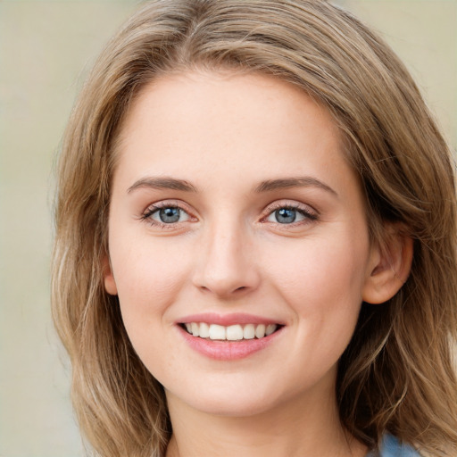 Joyful white young-adult female with long  brown hair and green eyes