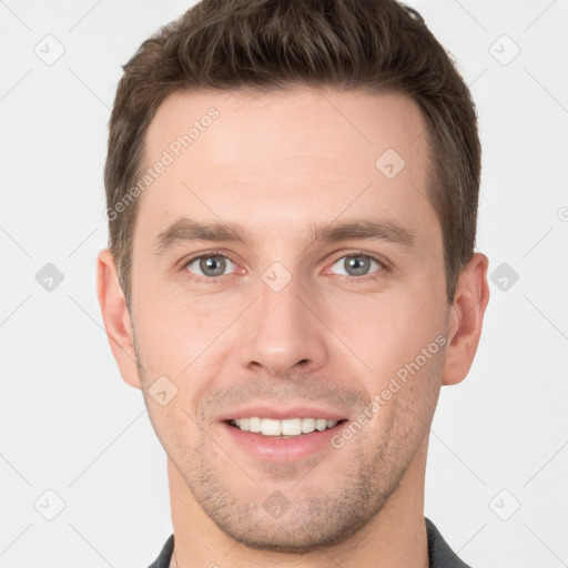 Joyful white young-adult male with short  brown hair and grey eyes