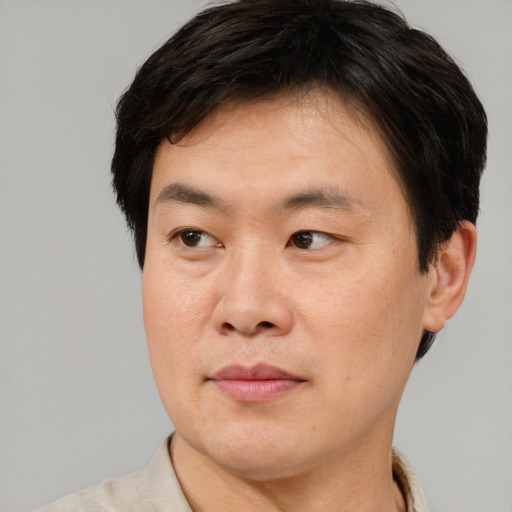 Joyful asian adult male with short  brown hair and brown eyes