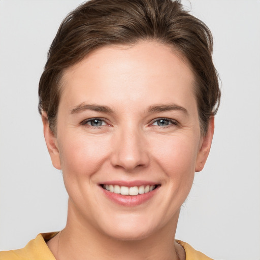 Joyful white young-adult female with short  brown hair and grey eyes