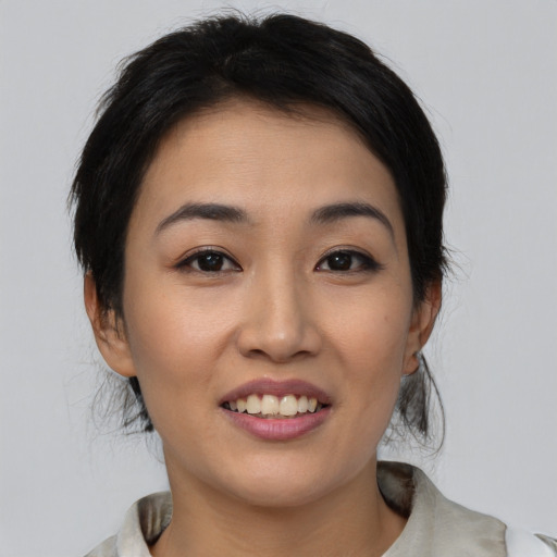 Joyful asian young-adult female with medium  black hair and brown eyes