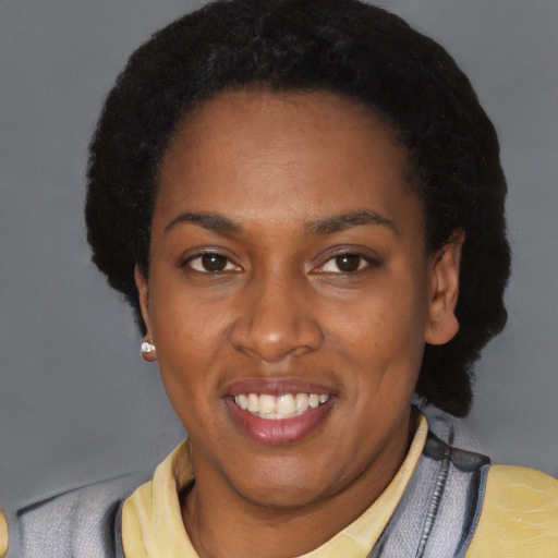 Joyful black young-adult female with short  black hair and brown eyes